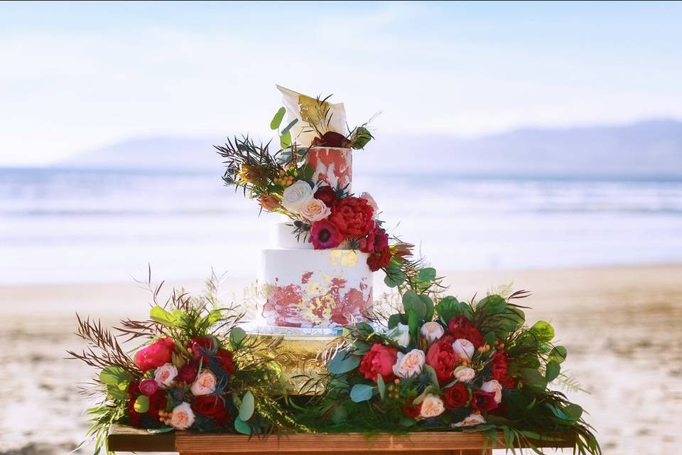 Wedding cake table and flowers by the beach