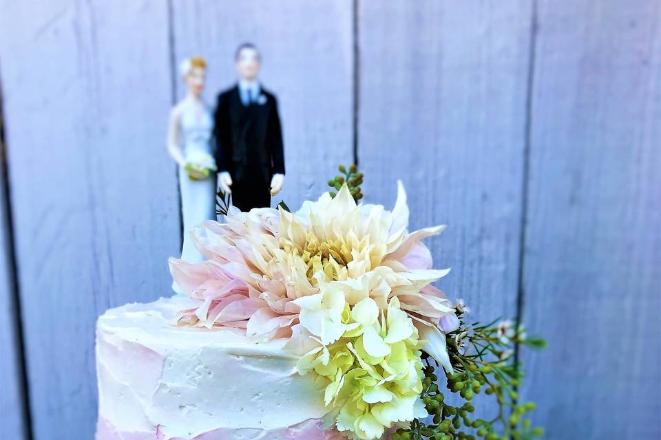 White and pink cake with figurines