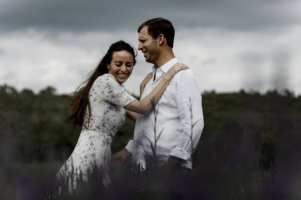 Couple hugging in a pasture