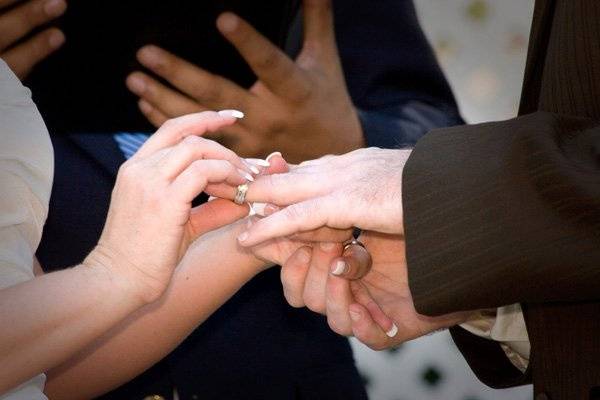 A bride places the ring on her new husband's finger