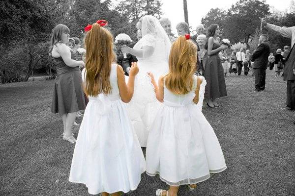 Flower girls holding the dress of the bride