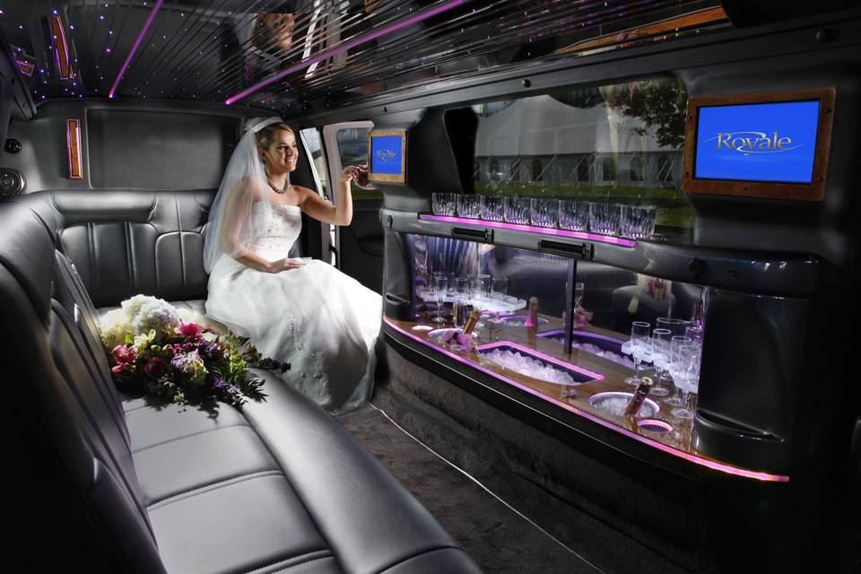 Accent lighting, beverage center, iPod/ MP3 player hook up and leather seating. Vehicle is stocked with ice, soda and water. Tuxedo attired chauffeurs pull out a red carpet for a complimentary toast. Classic.