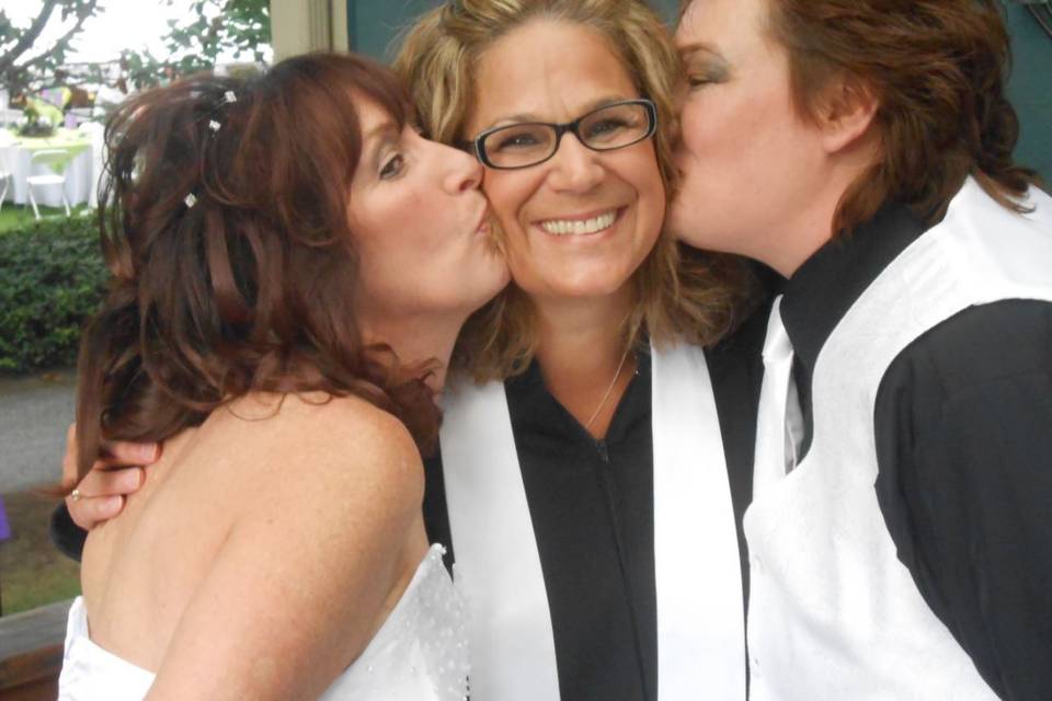 Couple kissing the cheeks of the officiant