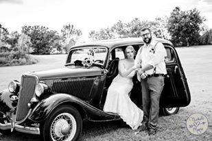 Bride and groom by their vintage car