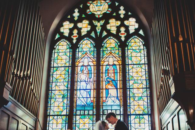 Couple standing under a stained glass window