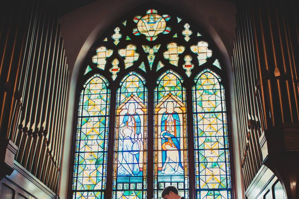 Couple standing under a stained glass window