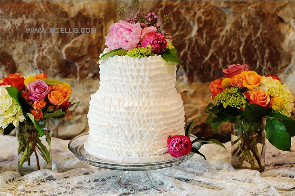 White wedding cake with pink flowers on top