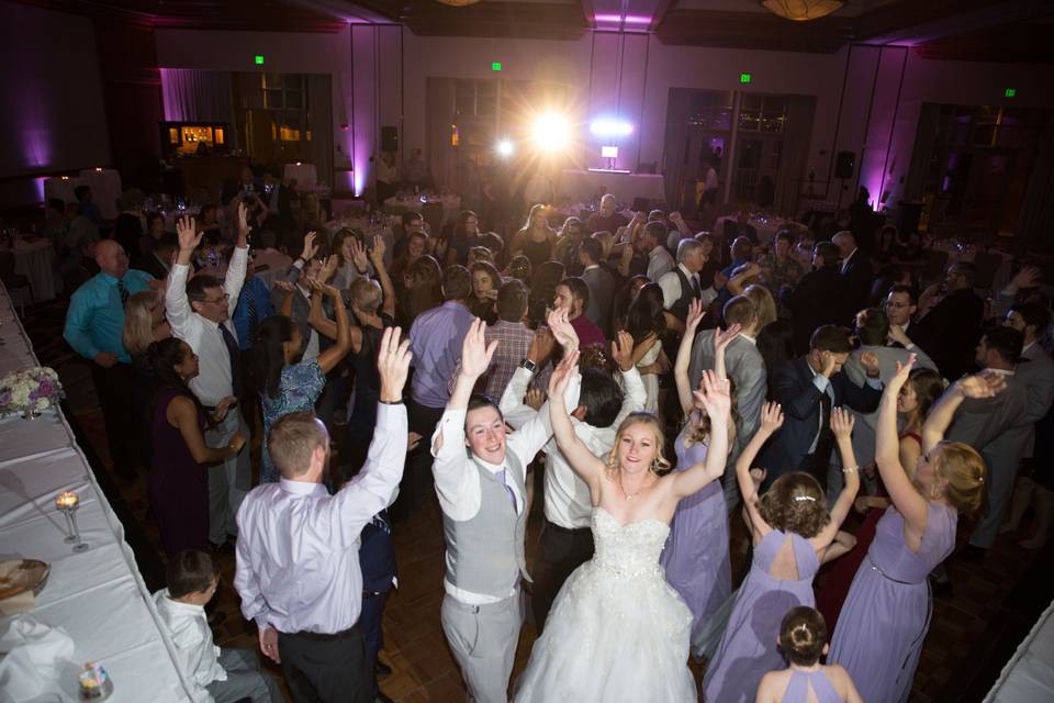 The couple with the bridesmaids and groomsmen dancing