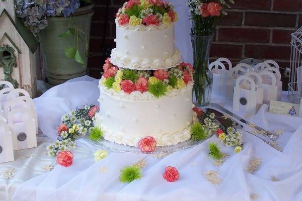 Buttercream cake w/ fondant dots. Decorated with Fresh mums, carnations, and daisies.