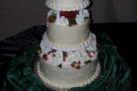 Wedding cake w/ fresh Gerberdaisies, carnations, and red accent flowers.