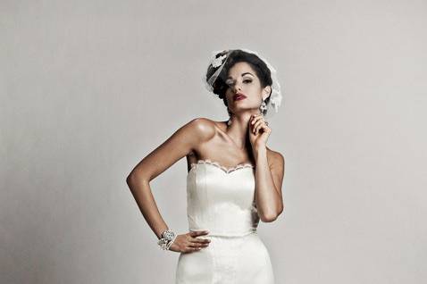 Enraptured:
Take his breath away in this stunning silk shantung gown.  Asymmetrical seaming wraps from a sweetheart neckline to the high slit trumpet skirt, finished in a modified chapel-length train.  Beautiful beading and feathers accent your waist. White and off-white
