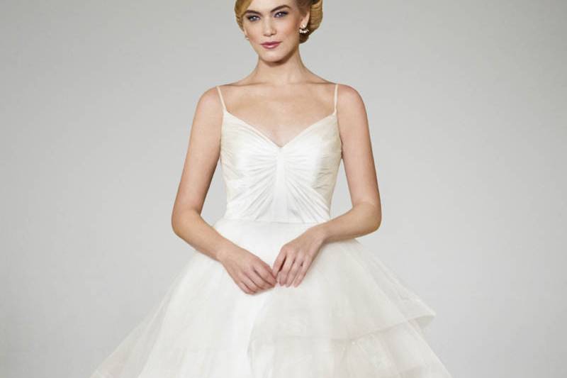 I feel pretty:
It will be alarming how charming you’ll feel in this synthetic charmeuse V-neck gown that grazes your shoulders elegantly, and wraps into a crescendo of tulle to the end of the modified chapel-length train. The sheer tulle cutout at the waist adds a bit of drama to make you feel ‘oh so pretty.’ White and off-white.