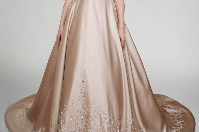 Style Wisteria <br> Swing into spring with this adorable tea length silk duchess gown adorned with a single layer of tulle and vines of embroidered branch-like lace. A V-neck and rouched cap sleeves provide the perfect frame for this ethereal, A-line beauty.