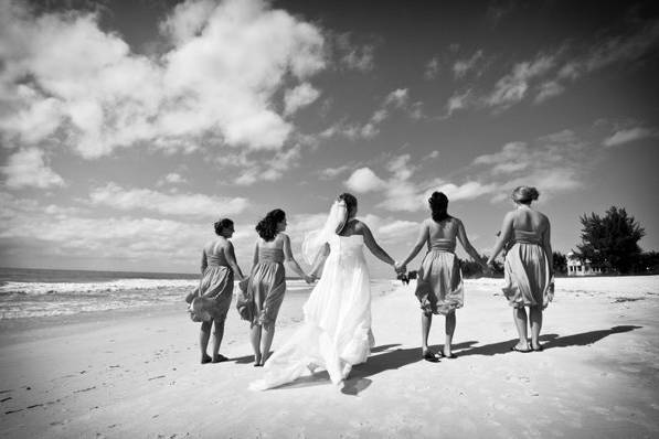 Bride and bridesmaids walking on the beach