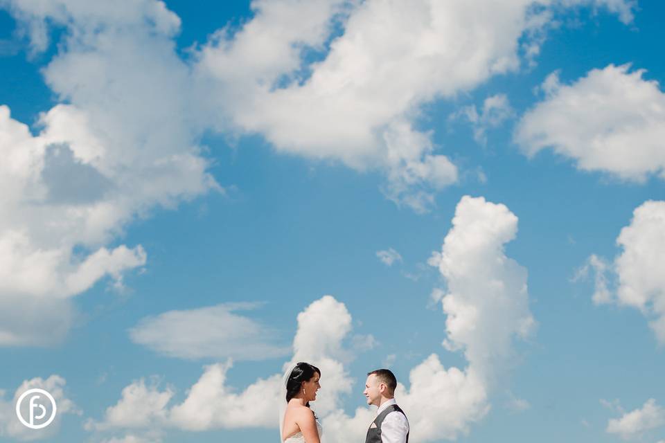 Newlyweds against blue sky