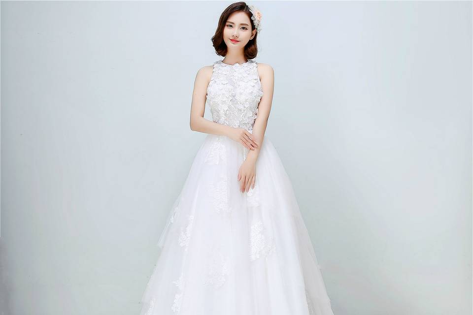 Dazzling in every way, this soft and romantic illusion lace wedding dress will ensure all eyes are on you on the big day! The intricate beaded floral laces embellishment on bodice and the layered soft tulle skirt embroidered with lace appliques add glamour. Finishing with a soft French lace netting without an inner layer of thick satin offers an illusive vision for the upper bodice and adds ultra-femininity to the bride.