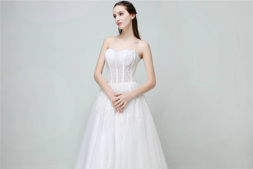 Covered by 3D little floral and vine laces, the upper bodice of this A-line gown is featured with concise floral lace design, streamlined silhouettes and luxe fabrics. The demure illusion lace with hand draped details make each piece unique for this dress. This concise but luxury dress is a perfect fit for brides who seek quality, high design style, and craftsmanship