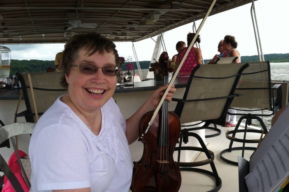 Violist Rochelle Naylor performs on a yacht for Orchestra Iowa's Sight and Sound auction.