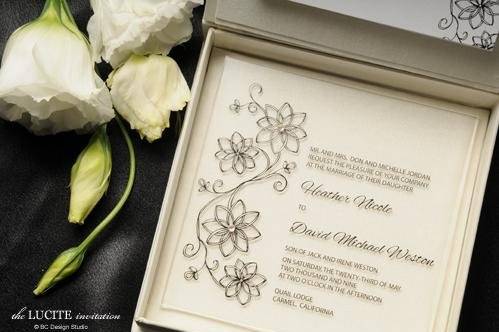 The modern Lucite wedding invitation is printed on plexiglas and accented with Swarovski crystals. Comes in an envelope but can be upgraded to a silk box. Design is customizable.