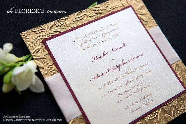 The Florence Wedding Invitation with gold embossed paper and satin ribbon from Brenna Catalano Design Studio. Ribbon and accent colors can be customized.