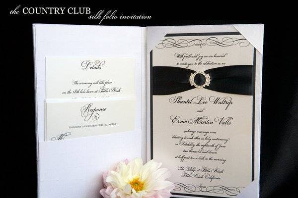 The Country Club silk wedding invitation folio with crystal buckle and satin ribbon from Brenna Catalano Design Studio. Pocket on left side to hold insert cards. Color can be customized.