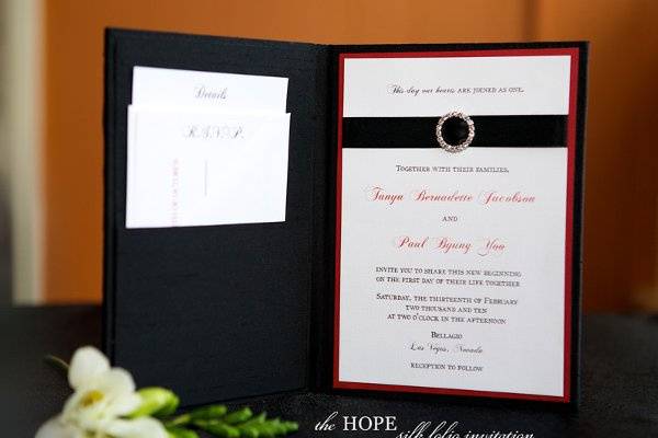 The Hope silk wedding invitation folio with crystal buckle and satin ribbon from Brenna Catalano Design Studio. Pocket on left side to hold insert cards. Color can be customized.