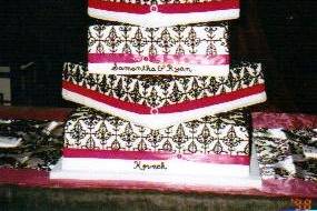 DAMASK DELIGHT:  This 4-tier design of alternating straight and turned square cakes is intereresting.  The damask design lends elegance and beauty to the overall effect.