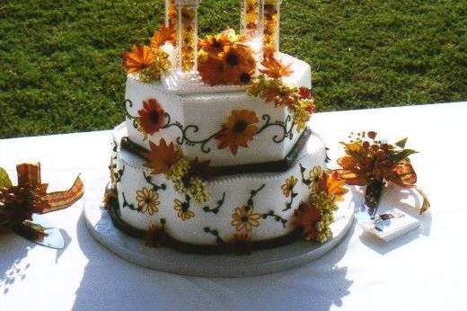 AUTUMN EXPRESSION:  This 3-tier cake with its yellow and orange daisies, leaves and vines will capture the heart of any lover of autumn.