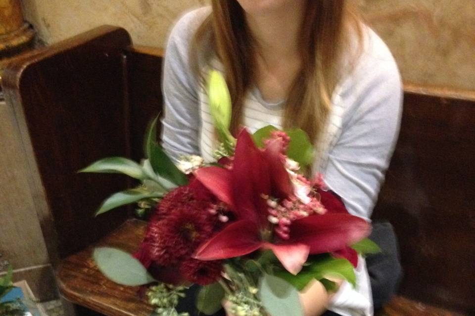 Wine colored lilies and greenery for a winter bridesmaid bouquet.