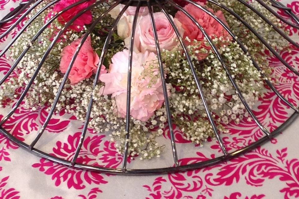 Fresh flowers are set under the base of a wedding cake stand.