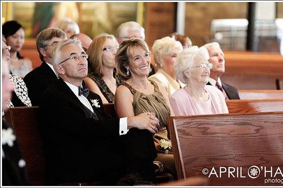 The mother of the bride smiles during the ceremony at St. Thomas More Catholic Church in Englewood, CO