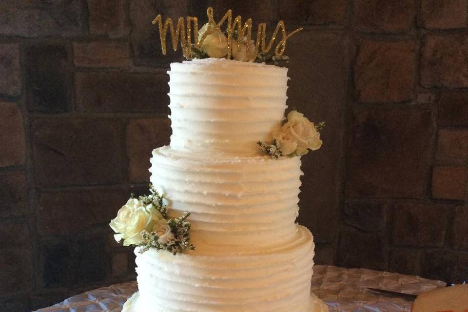 Four tier white wedding cake with flowers