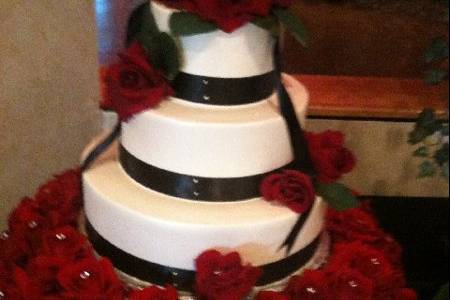 Wedding cake with black ribbons and red roses