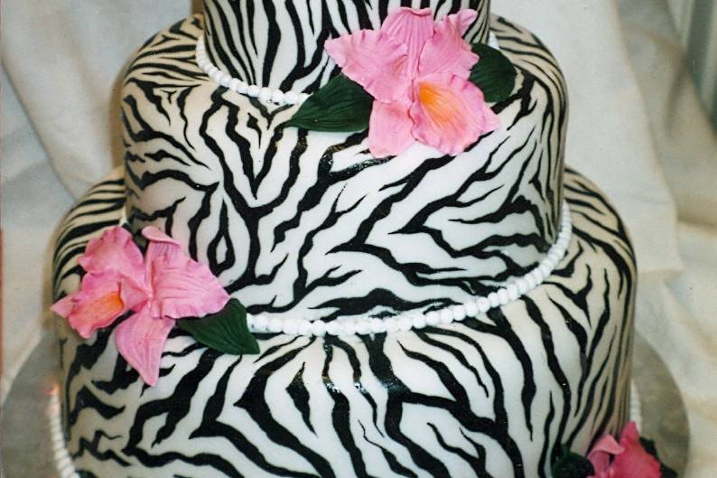 Hot pink sugar orchids add pop to this zebra-printed rolled fondant cake