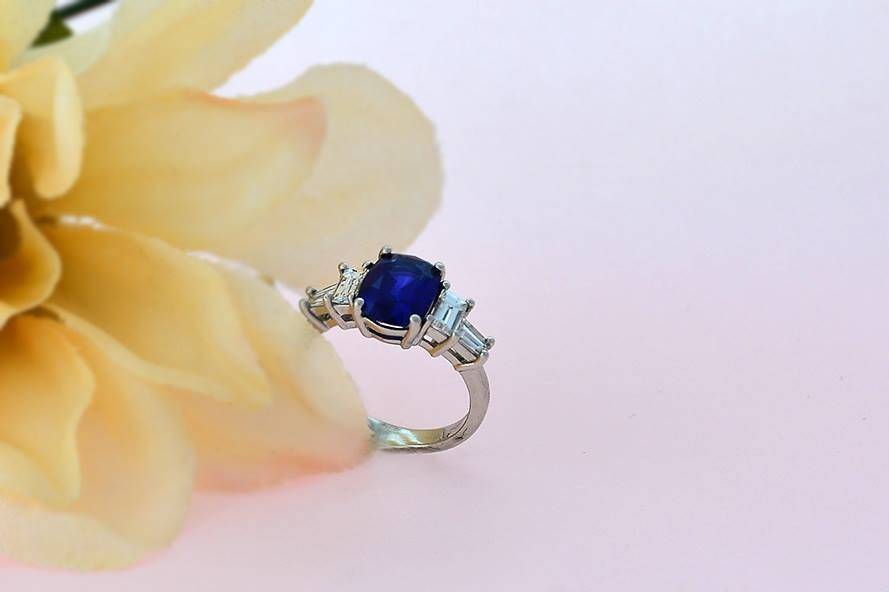 Sapphire flanked by emerald-cut diamonds