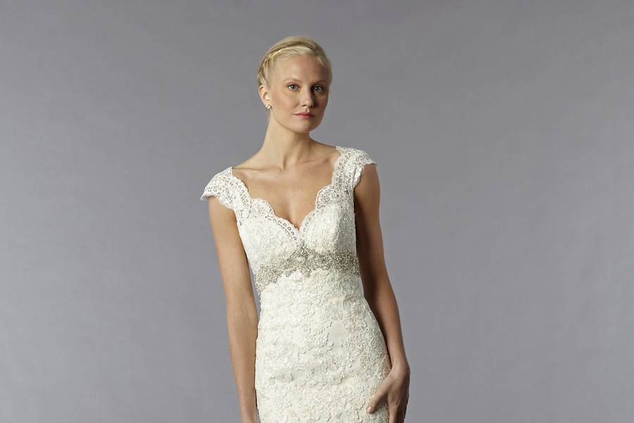 Style 33019787 This mermaid gown features a v-neck neckline with an empire waist in lace and beaded embroidery. It has a chapel train and cap sleeves. This gown is available in Plus Sizes, and is Exclusive to Kleinfeld Bridal.