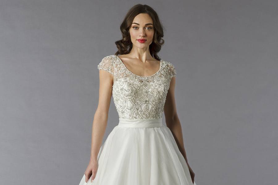 Style 32797540 This ball gown features a scoop neckline with a natural waist in tulle and beaded embroidery. It has a chapel train and cap sleeves. This gown is Exclusive to Kleinfeld Bridal.
