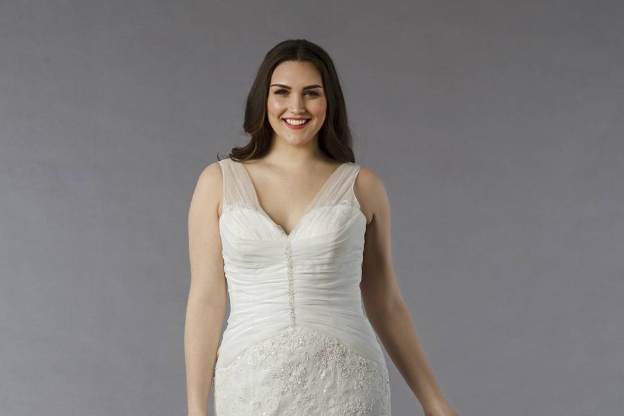 Style 32643124 This a-line gown features a v-neck neckline with an asymmetric waist in lace and beaded embroidery. It has a chapel train and a tank top. This gown is available in Plus Sizes, and is Exclusive to Kleinfeld Bridal.