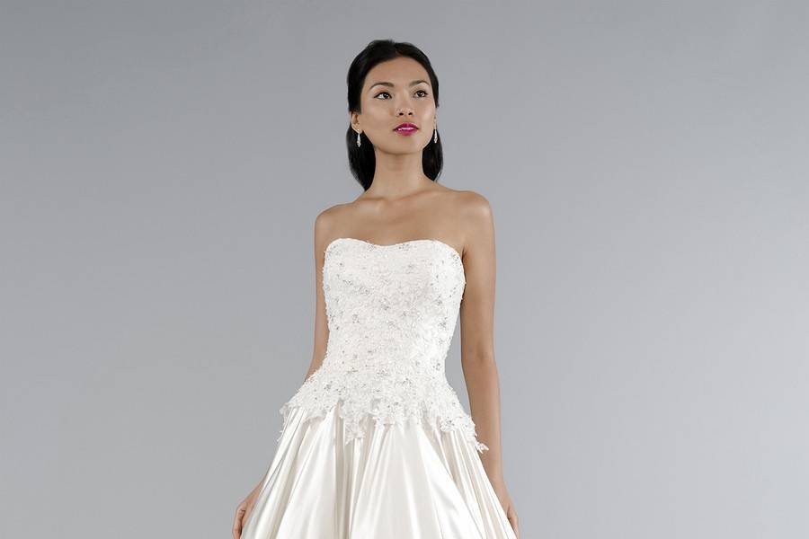 Style #32943623 This a-line gown features a sweetheart neckline with a dropped waist in silk satin and beaded lace. It has a chapel train. This gown is Exclusive to Kleinfeld Bridal.