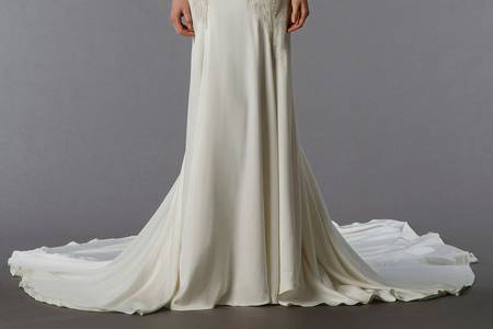 Style 32825309  This sheath gown features an illusion neckline with in silk crepe. It has a chapel train. This gown is Exclusive to Kleinfeld Bridal.