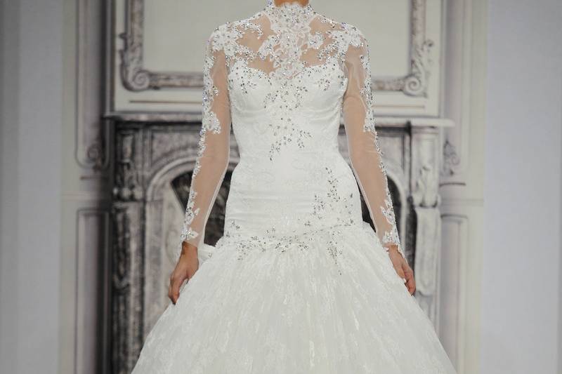 Style # 32813560This ball gown features an high neck neckline with a dropped waist in beaded lace. It has a chapel train and long sleeves. This gown is Exclusive to Kleinfeld Bridal.