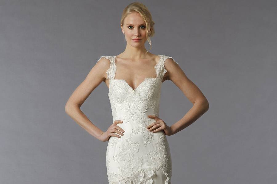Style 33002957 This sheath gown features a sweetheart neckline with a dropped waist in lace. It has a sweep train and cap sleeves. This gown is Exclusive to Kleinfeld Bridal.