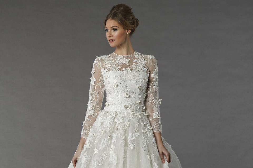 Tony Ward 2V2	This a-line gown features an illusion neckline with a natural waist in chiffon and beaded lace. It has a sweep train and long sleeves.