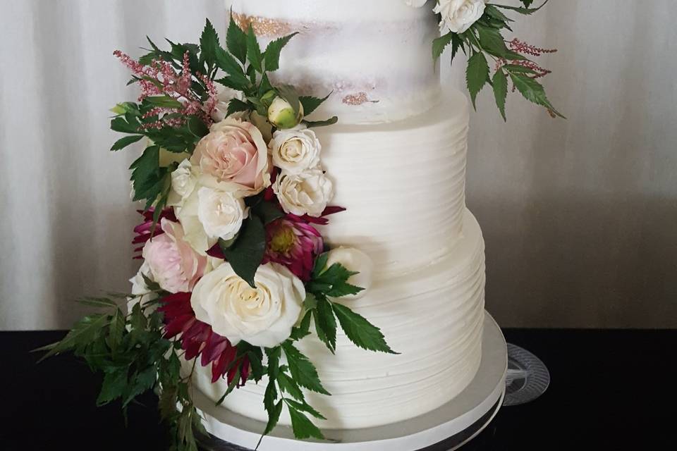 Four tier wedding cake with white and magenta flowers