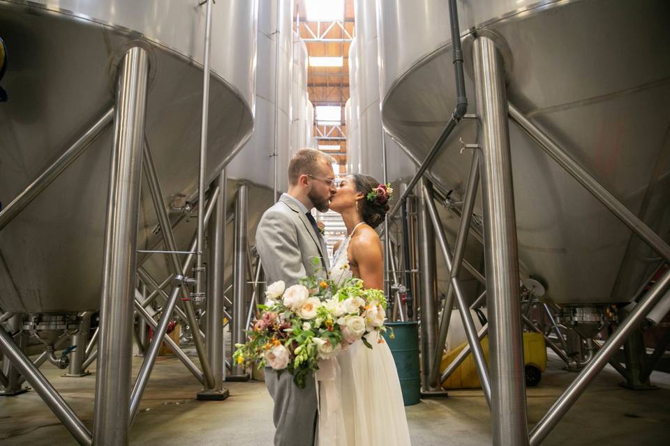 Newlyweds kiss by the brewery