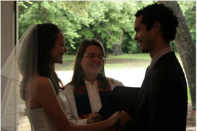 Reverend hugging the newlyweds