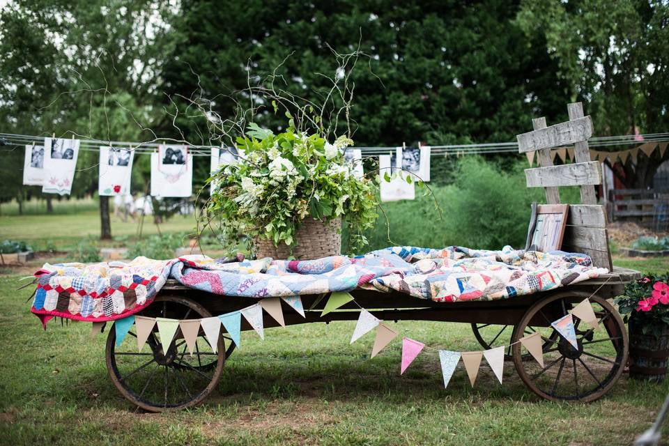 A spring garden wedding with lots of rustic, vintage, shabby-chic details.  Love the antique farm wagon with quilts and bunting!