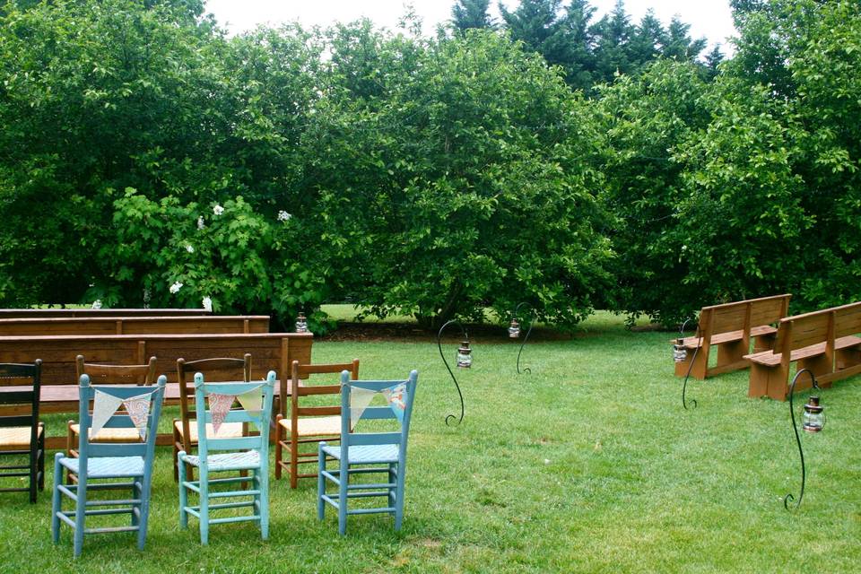 A spring garden wedding with lots of rustic, vintage, shabby-chic details.  Love the pews and ladder back chairs!