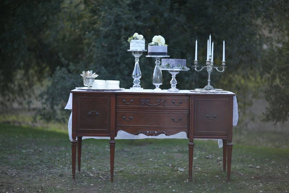 Mahogany buffet with silver candlesticks and cake plates.