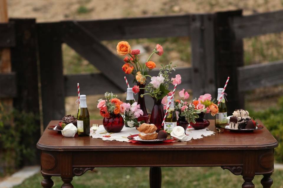 Vintage dining table with ruby glass vases and vintage table cloth.